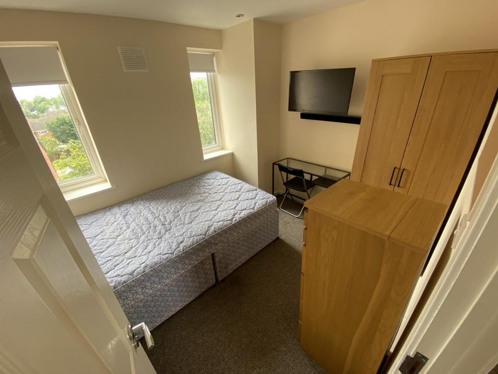 A bright and tidy double bedroom featuring larg...