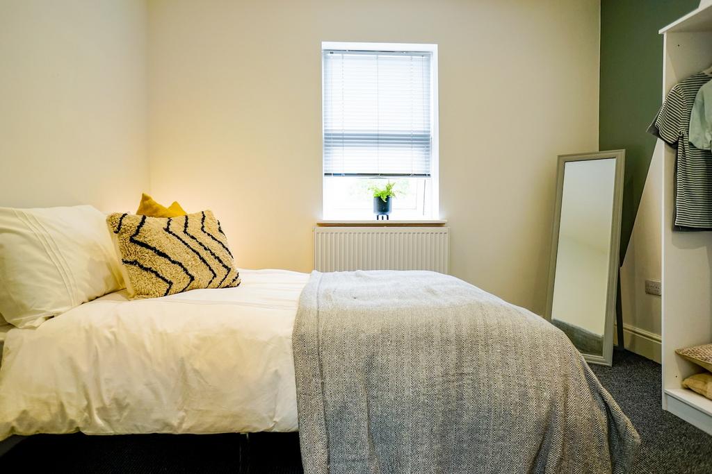 A bright and inviting bedroom featuring a comfo...