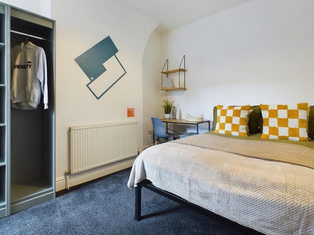 A bright and inviting double bedroom with a sty...