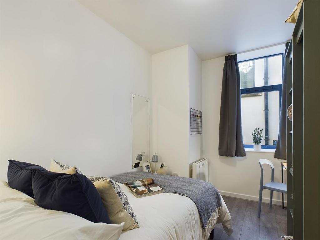 A bright and inviting double bedroom with styli...