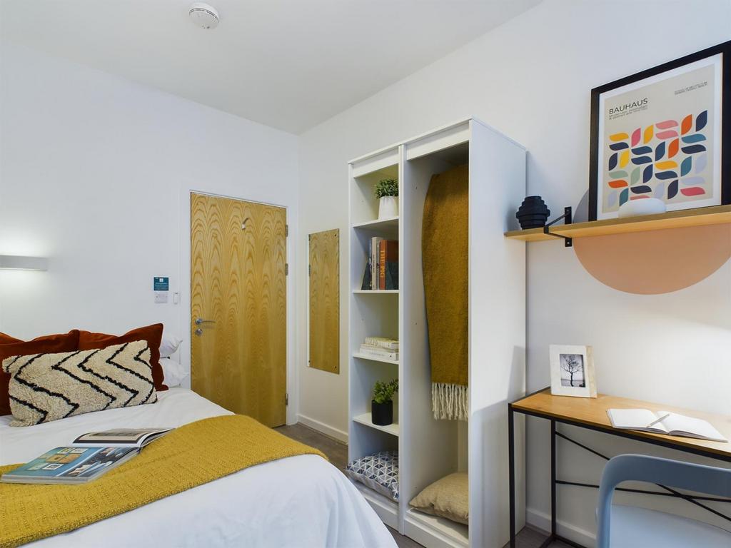 A bright and inviting double bedroom with styli...