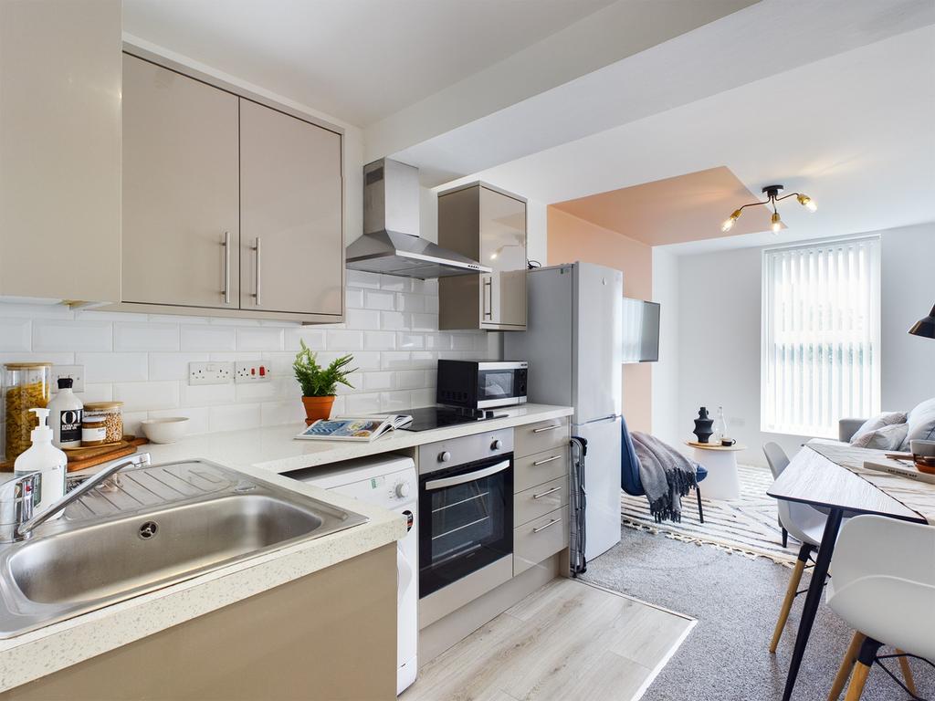 A modern and tidy kitchenette with ample natura...