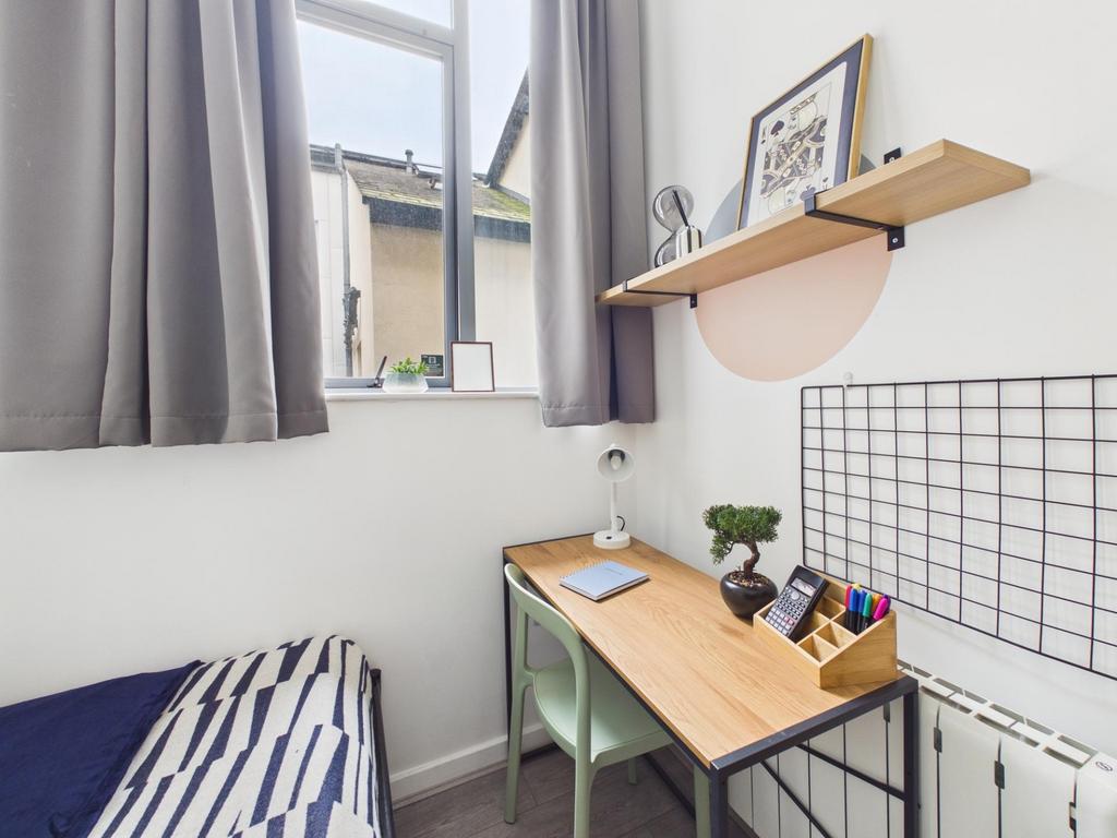 Bright, tidy single bedroom with a neat desk an...