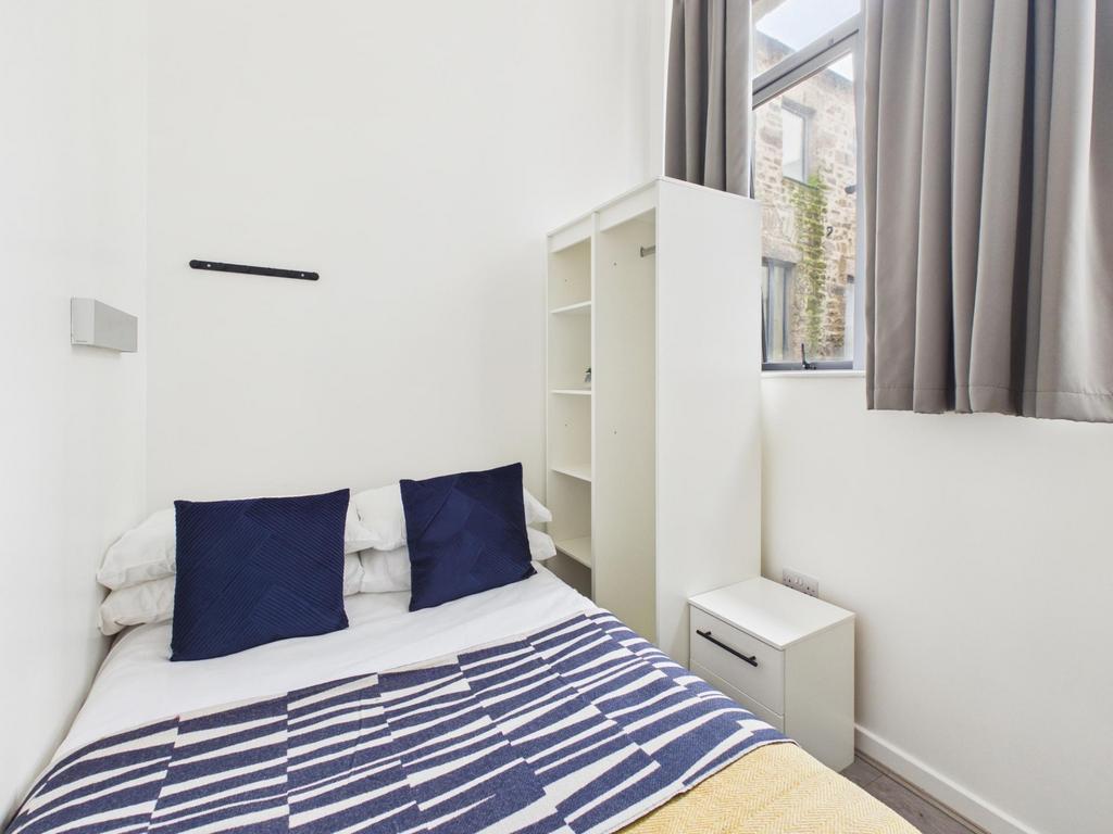 Bright, simply furnished bedroom with a neatly ...