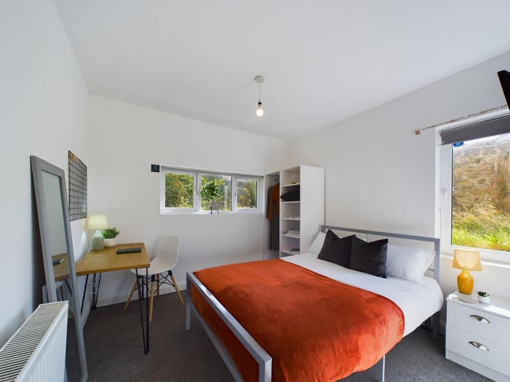 A spacious, well-lit master bedroom featuring a...