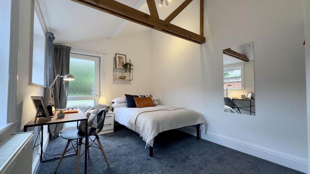 A spacious and bright double bedroom with moder...