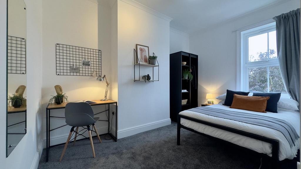 A bright and inviting double bedroom featuring ...