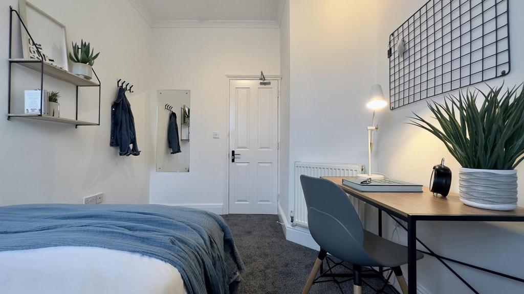 A bright and stylish double bedroom featuring a...