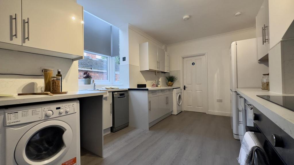 A bright and modern kitchen featuring ample sto...