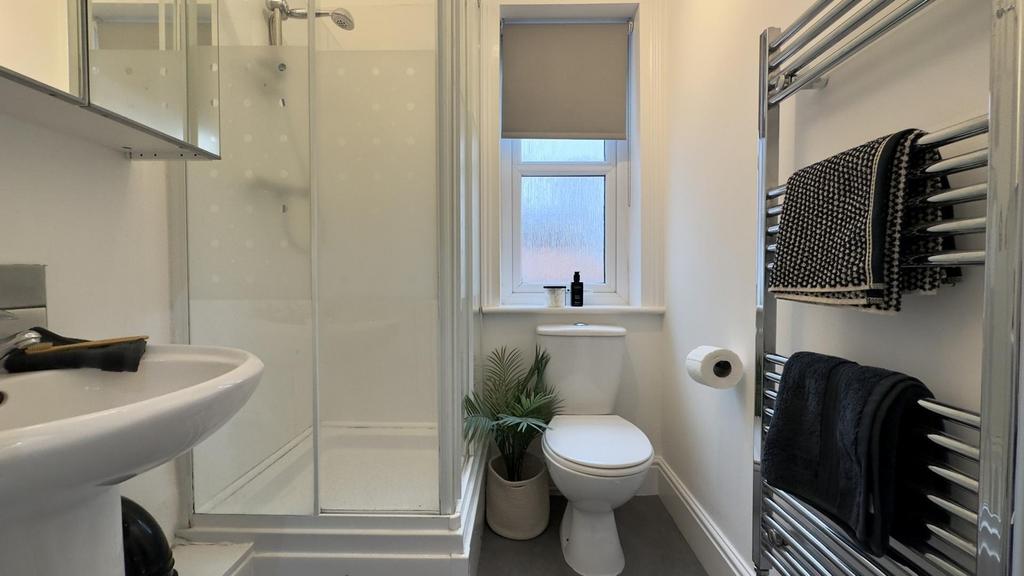 A modern and tidy bathroom featuring a sleek sh...