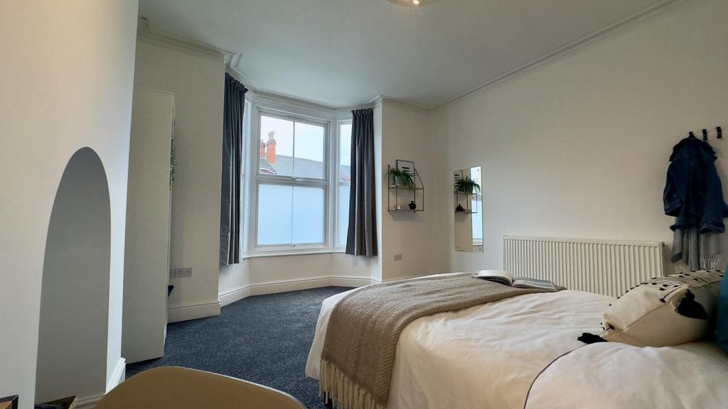 A spacious and bright double bedroom with large...