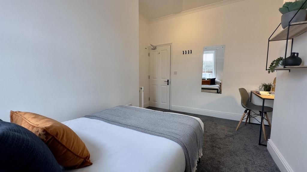 A spacious and inviting double bedroom with mod...