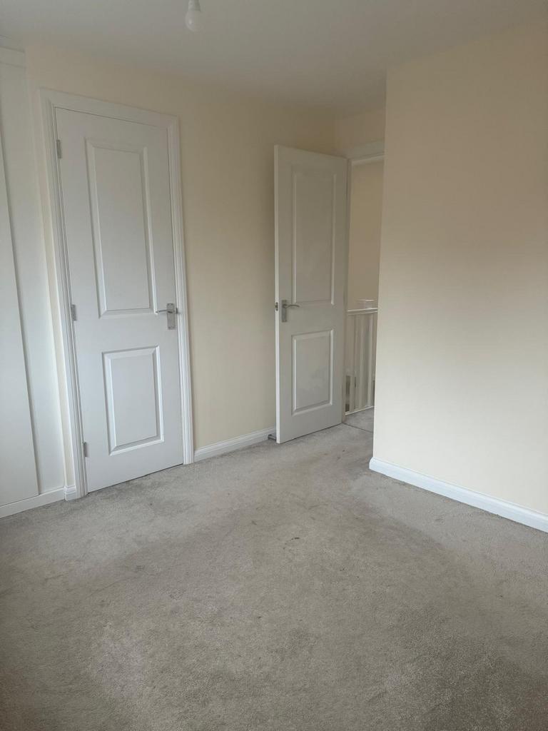 Bright, neutral bedroom with light cream walls,...