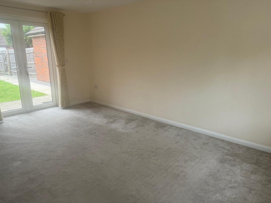 Bright, neutral living room with full-height gl...