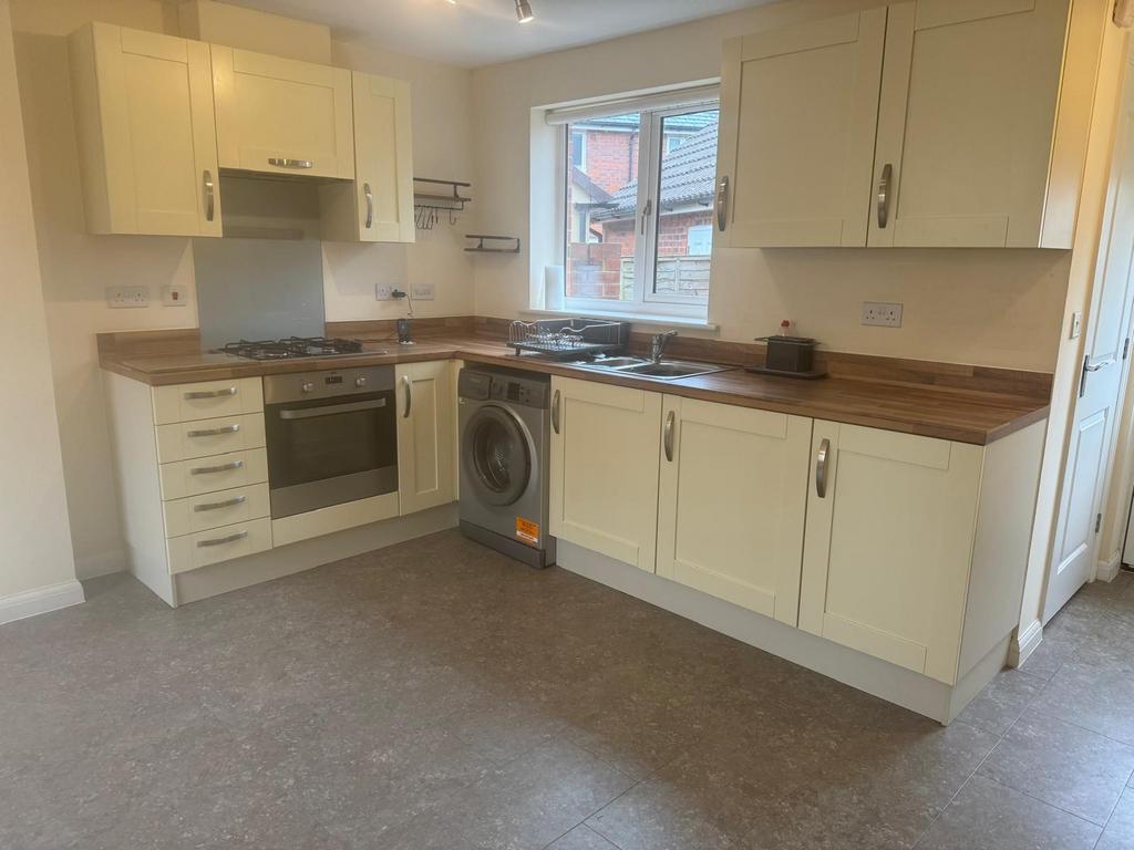 Bright, modern fitted kitchen with cream shaker...