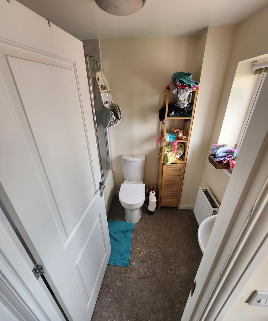 Compact, well-lit bathroom with a modern toilet...