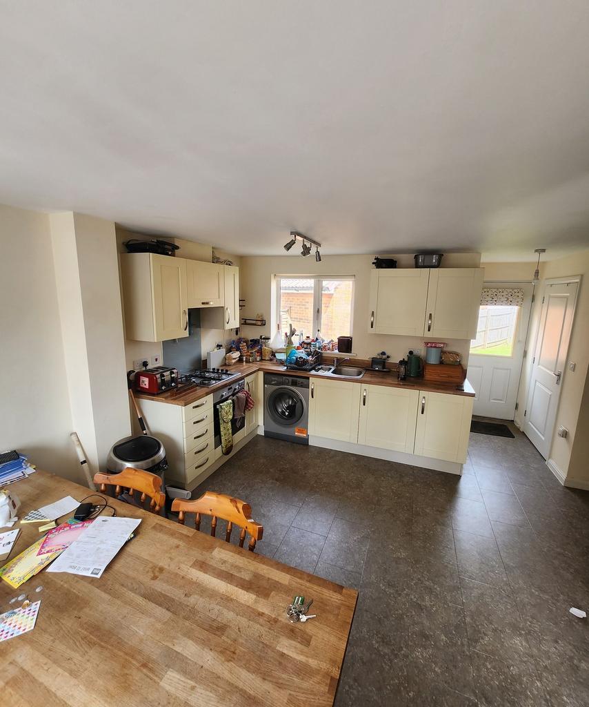 Bright open-plan kitchen with cream cabinetry, ...