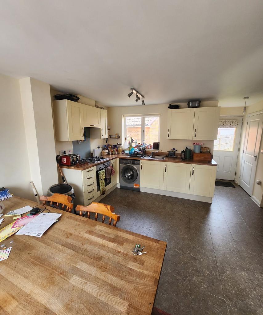 Bright open kitchen with light cream cabinets, ...