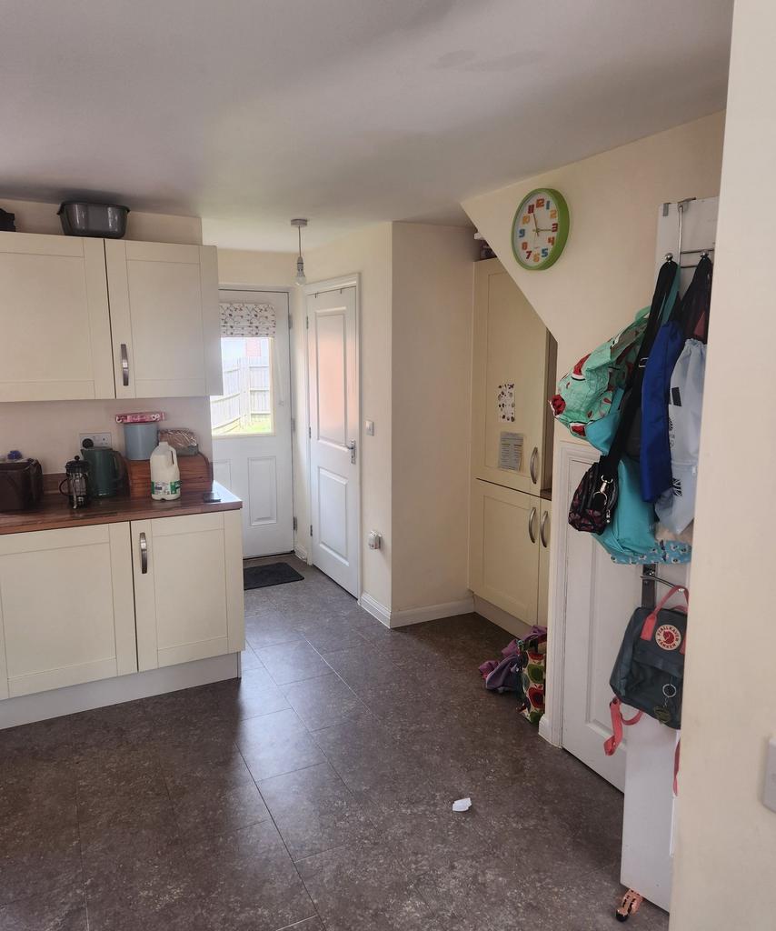 Bright, modern kitchen with cream cabinetry, wo...
