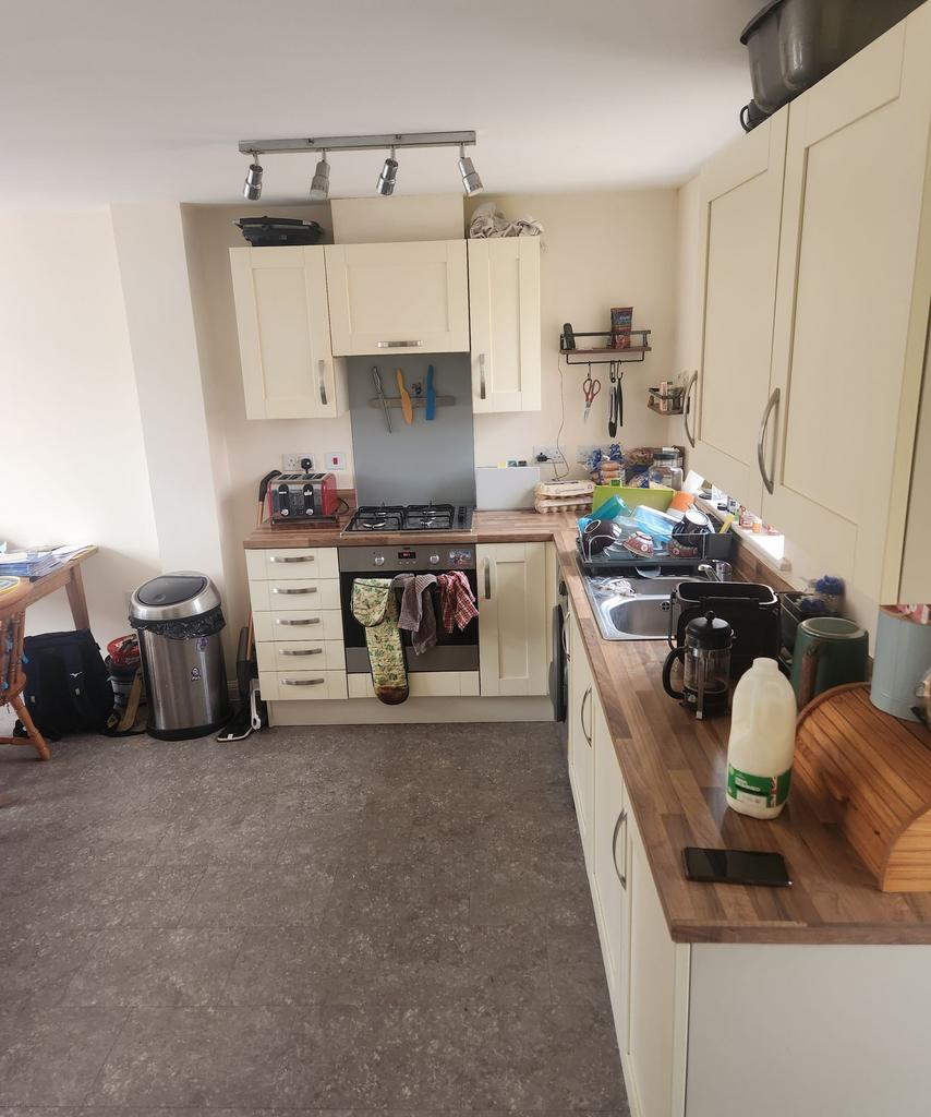 Bright galley-style kitchen with cream shaker c...