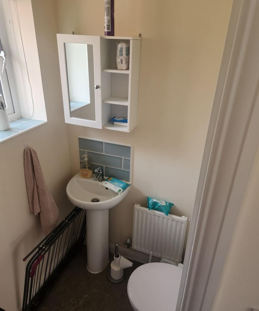 Compact, well-kept bathroom with a pedestal sin...