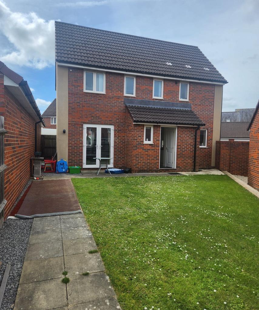 Well-maintained rear garden with a neat lawn, p...