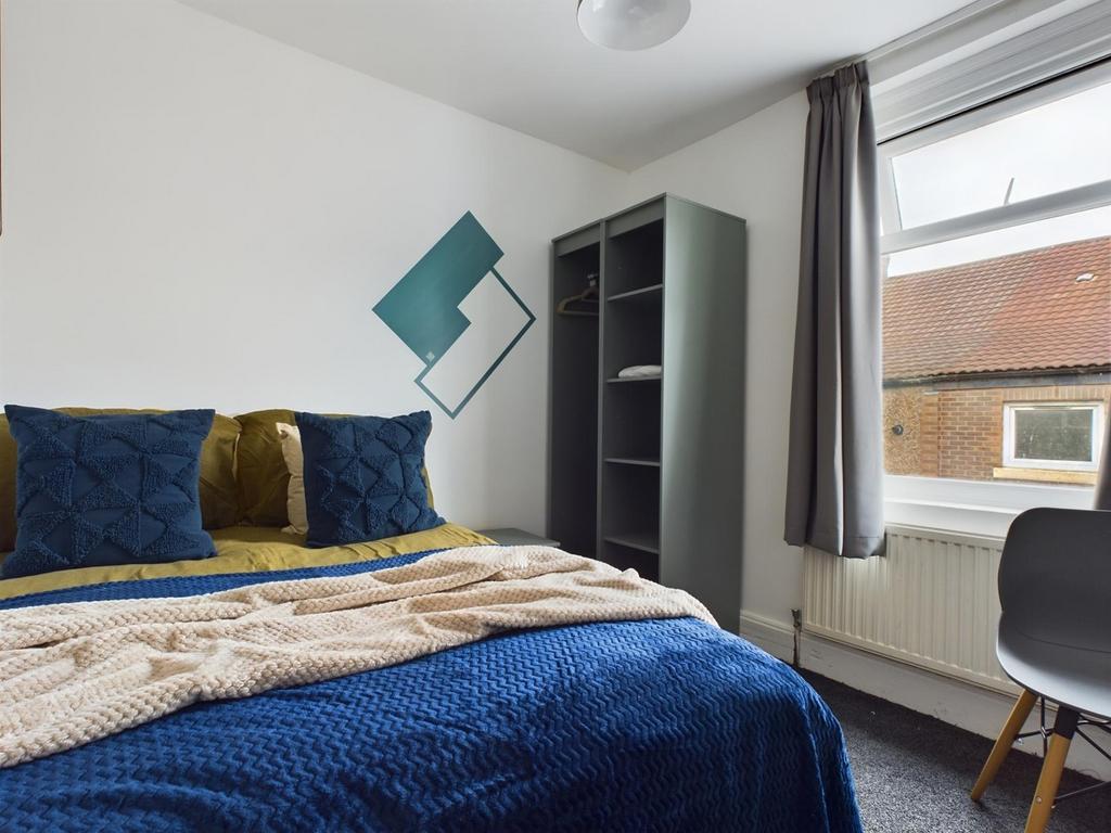 A cozy and well-lit double bedroom featuring st...