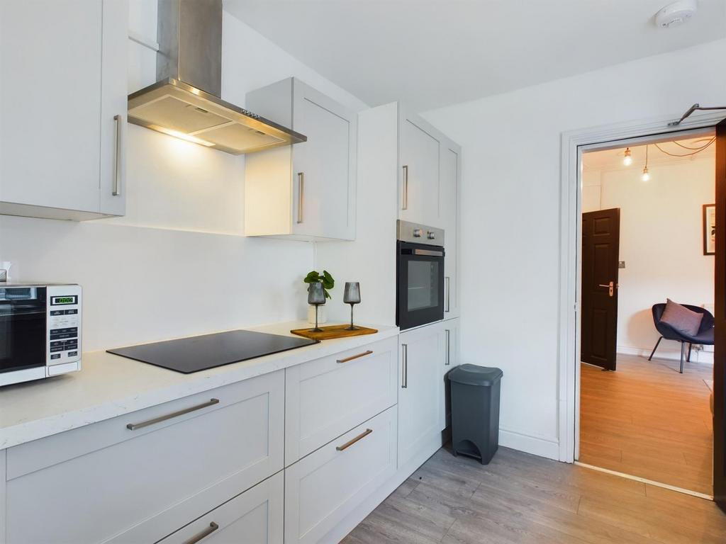 A modern and tidy kitchenette with ample natura...