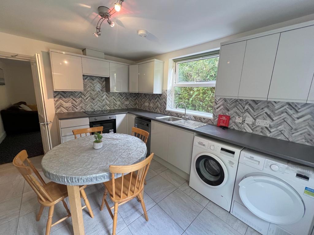 A bright and modern kitchen featuring ample cou...