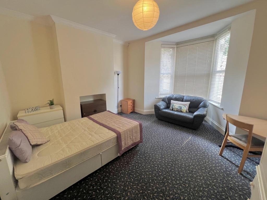 A spacious and well-lit double bedroom featurin...