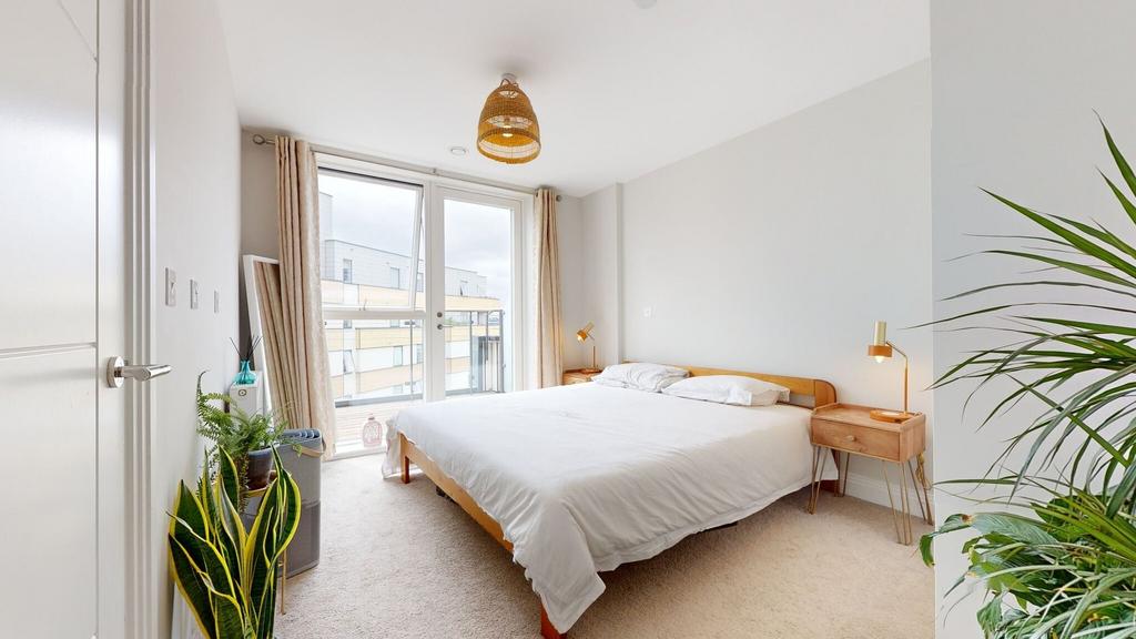 Bright, modern master bedroom with a large doub...
