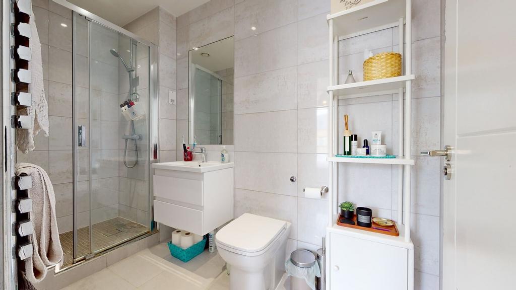 Bright, modern bathroom with a glazed shower en...