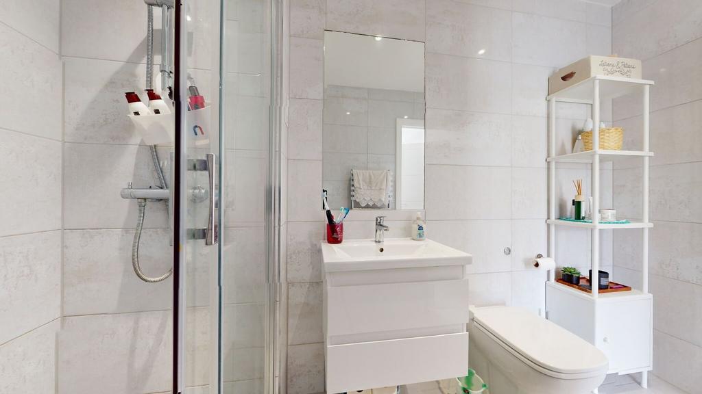 Bright, modern bathroom with a glass-enclosed s...