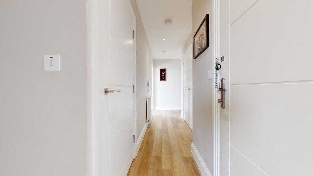 Bright, modern hallway with light wood flooring...