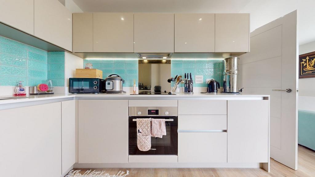 Modern fitted kitchen with glossy cream cabinet...