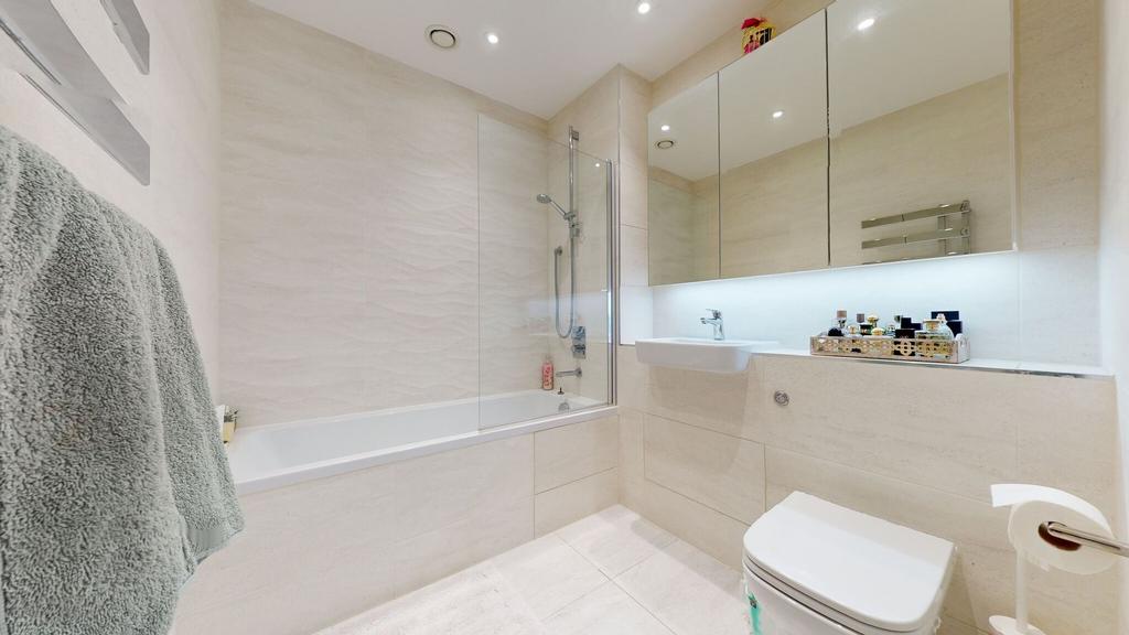 Bright, modern bathroom with a combined bath an...