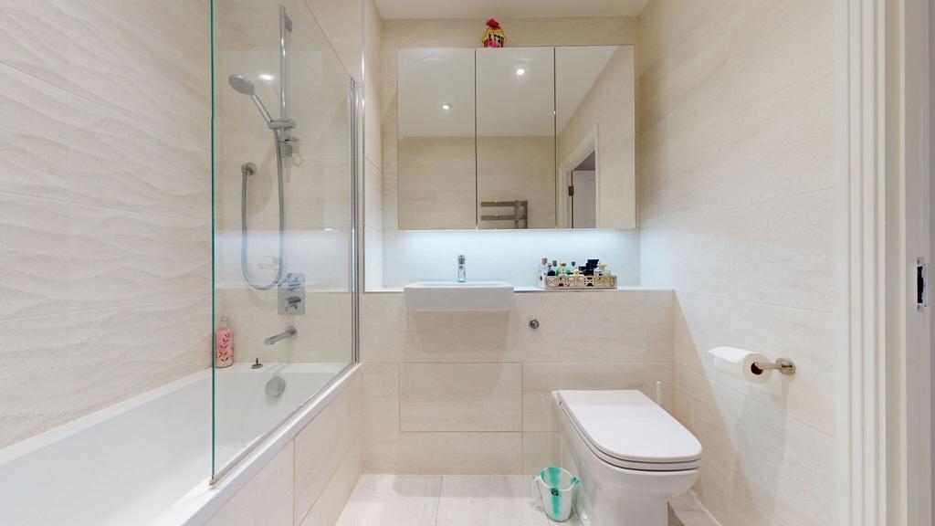 Bright, modern bathroom with a bathtub and show...