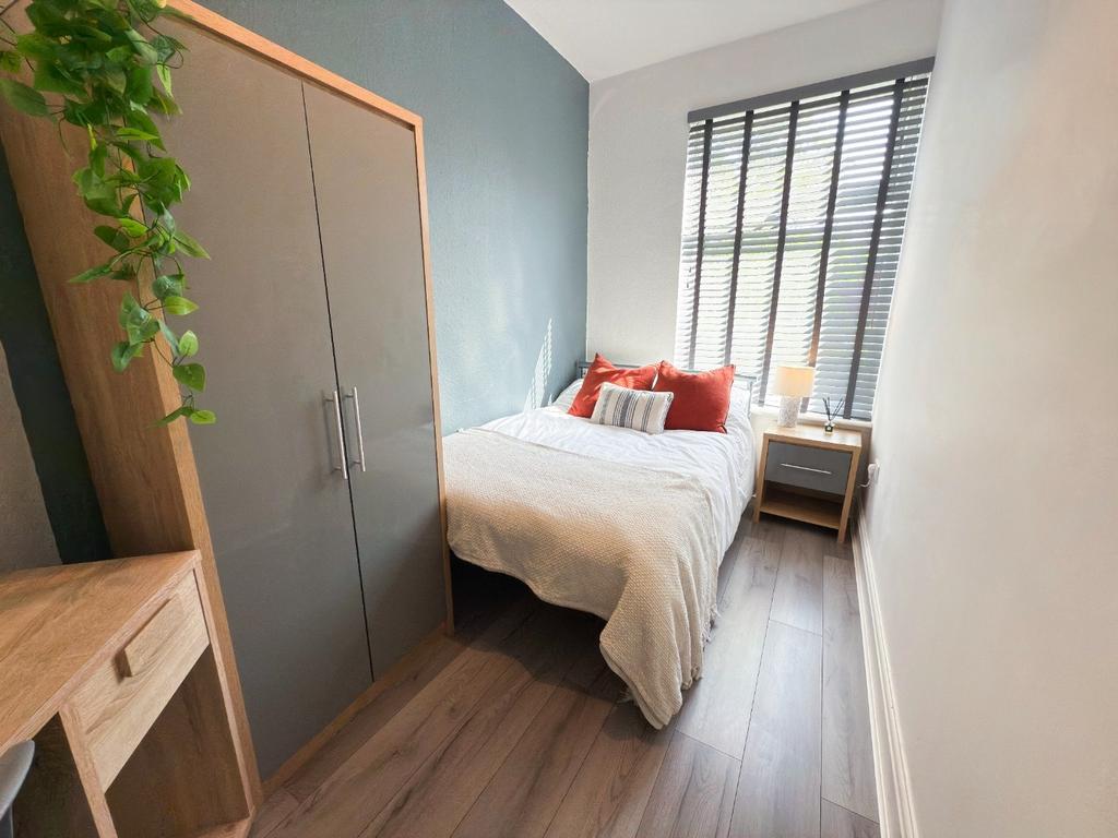 Bright, neatly styled double bedroom with conte...