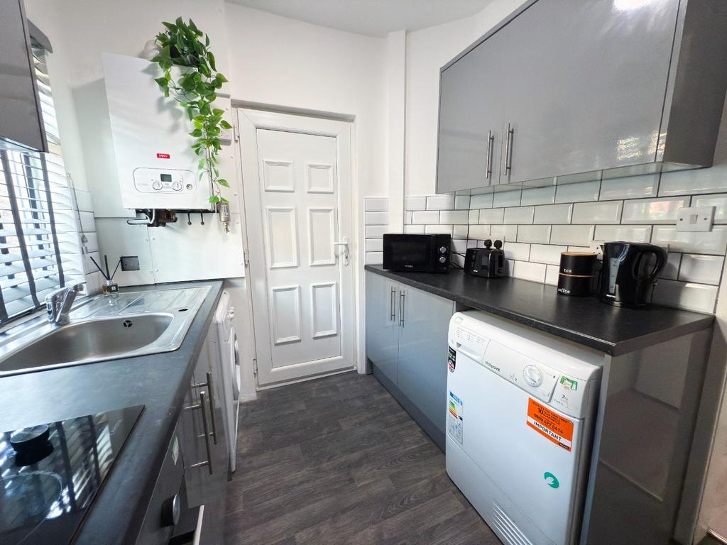 Bright modern kitchen with sleek grey cabinets,...