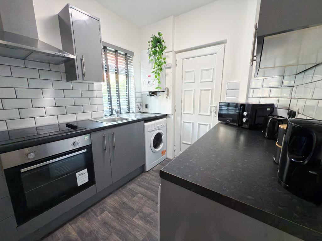 Modern galley kitchen with grey cabinetry, inte...