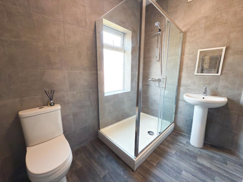 Modern bathroom with a corner glass shower encl...