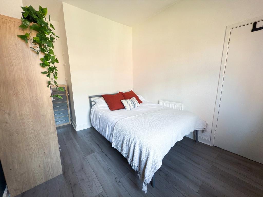 Bright, simply furnished double bedroom with a ...