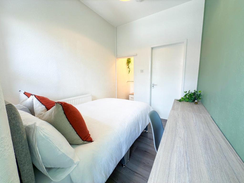 Bright, neatly styled bedroom with a comfortabl...