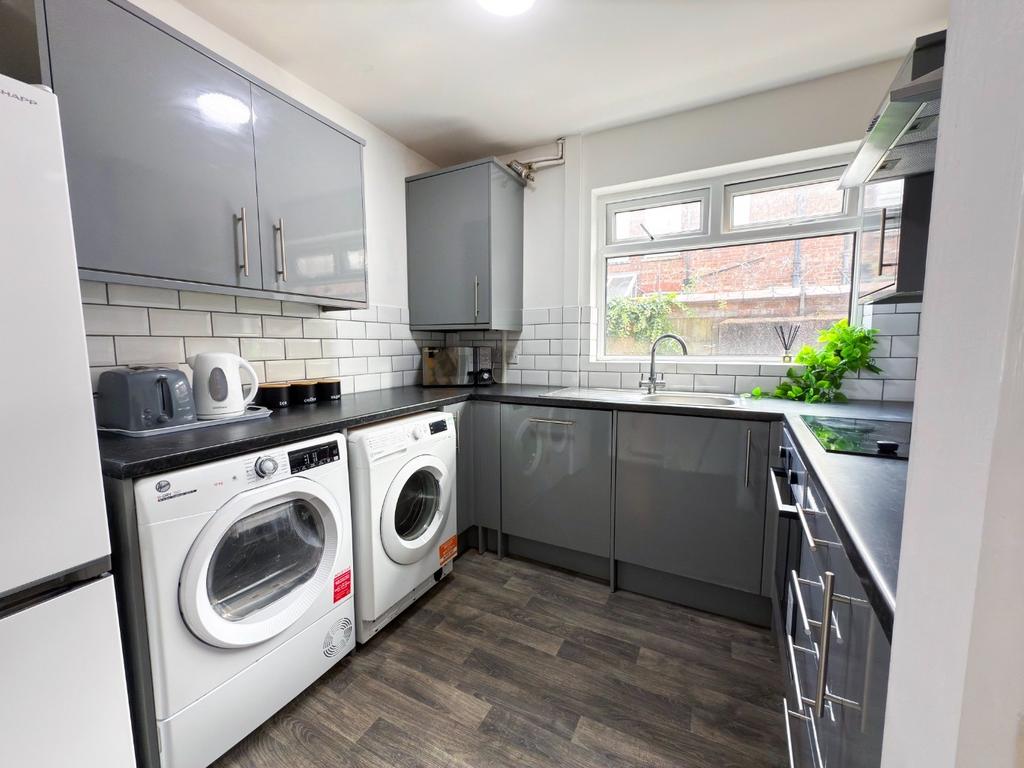 Modern fitted kitchen with sleek grey cabinets,...