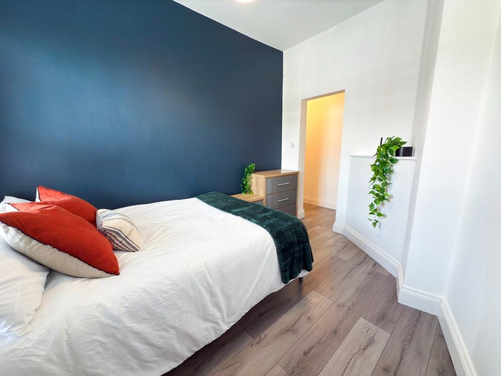 Bright, modern double bedroom with a feature da...