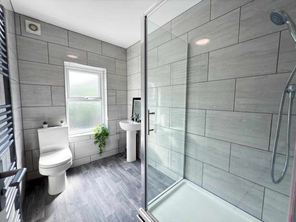 Bright, modern bathroom featuring a walk-in sho...