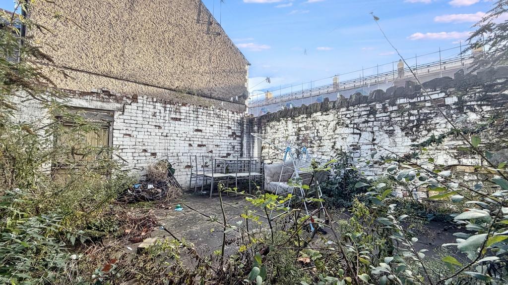 Enclosed rear courtyard with paved seating area...