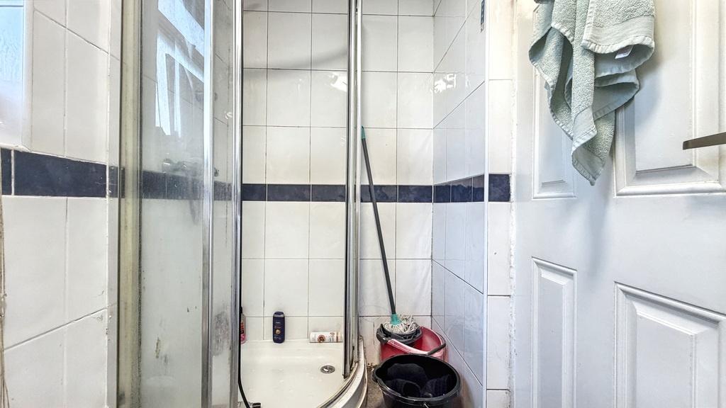 Compact bathroom with a curved glass shower enc...