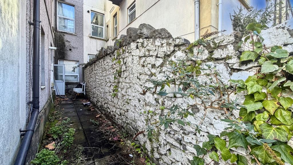 Narrow external side passage with a rustic ston...
