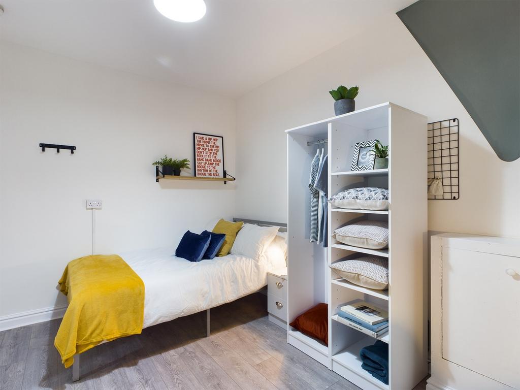 A bright and tidy double bedroom featuring mode...